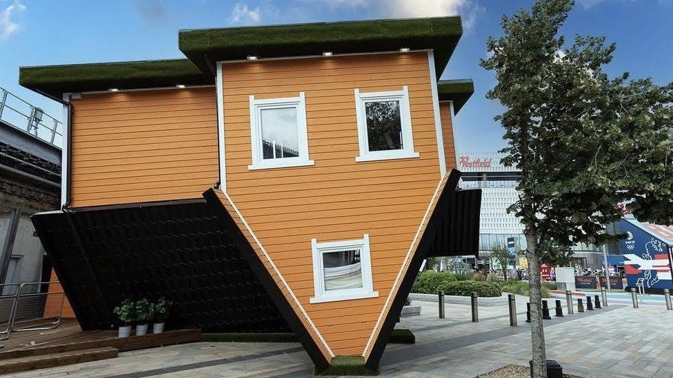 How is the Upside Down House designed to appear to visitors?